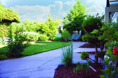 A serene garden pathway with seating and greenery