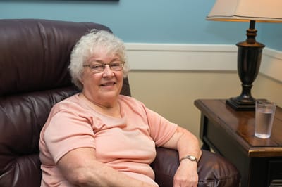 Senior woman smiling in a cozy lounge chair