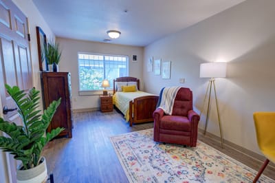Cozy interior of a resident room with a bed and chair