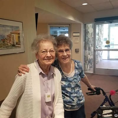 Two senior women smiling in a common area