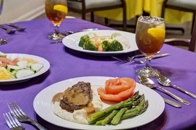 Elegant dining setup with plates of food on a purple tablecloth