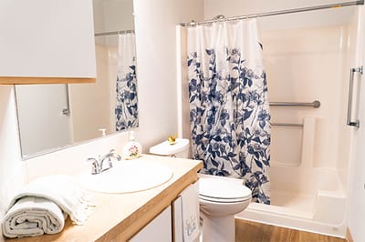 Clean and bright bathroom with floral shower curtain