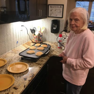 A resident making pancakes in a kitchen