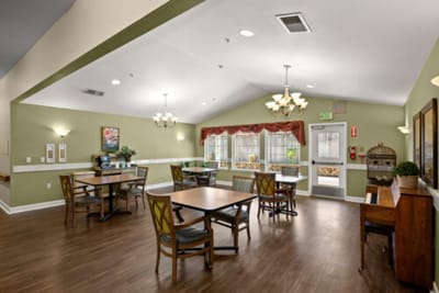 Bright common area with tables and chairs in a care facility