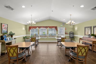 Interior view of a common area with tables and piano
