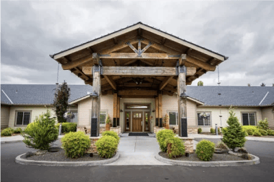 Front entrance of a senior living facility with a wooden awning