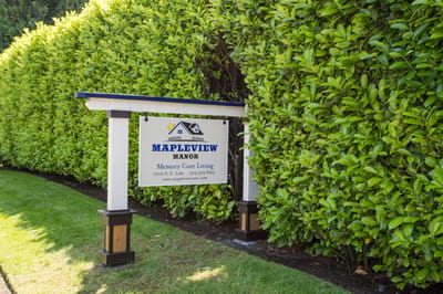Signage for Mapleview Manor surrounded by greenery