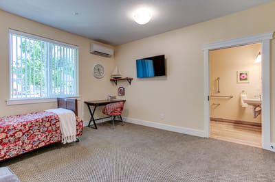 A private resident room with a bed and desk