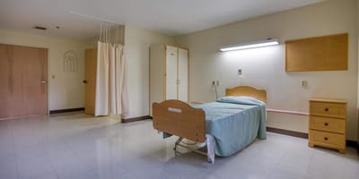 Interior view of a resident room with a bed and wardrobe