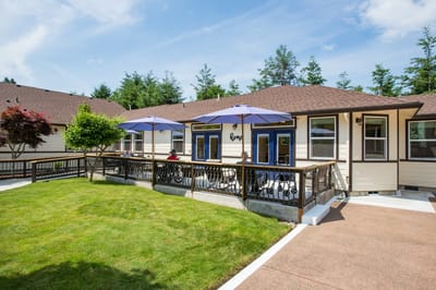 Outdoor area with seating and umbrellas at a senior living facility