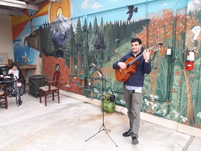 A resident enjoying live music in an outdoor setting