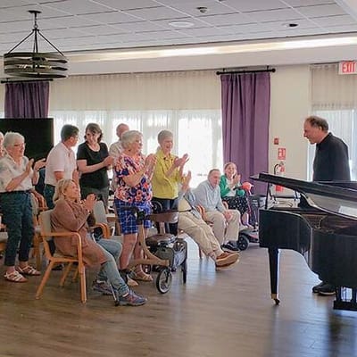 Residents enjoying a musical performance in a common area