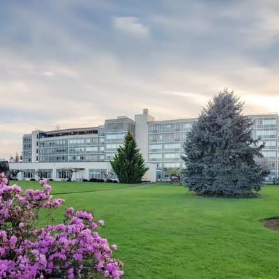 Exterior view of Mt Angel Towers surrounded by green lawn and flowers