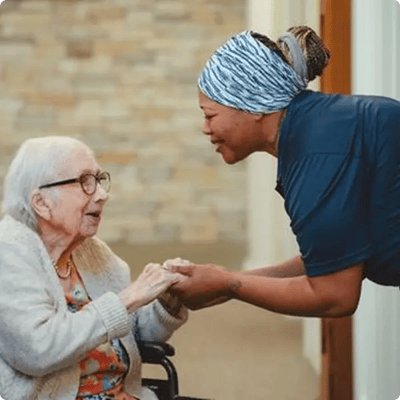 Caregiver interacting with a resident in a hallway
