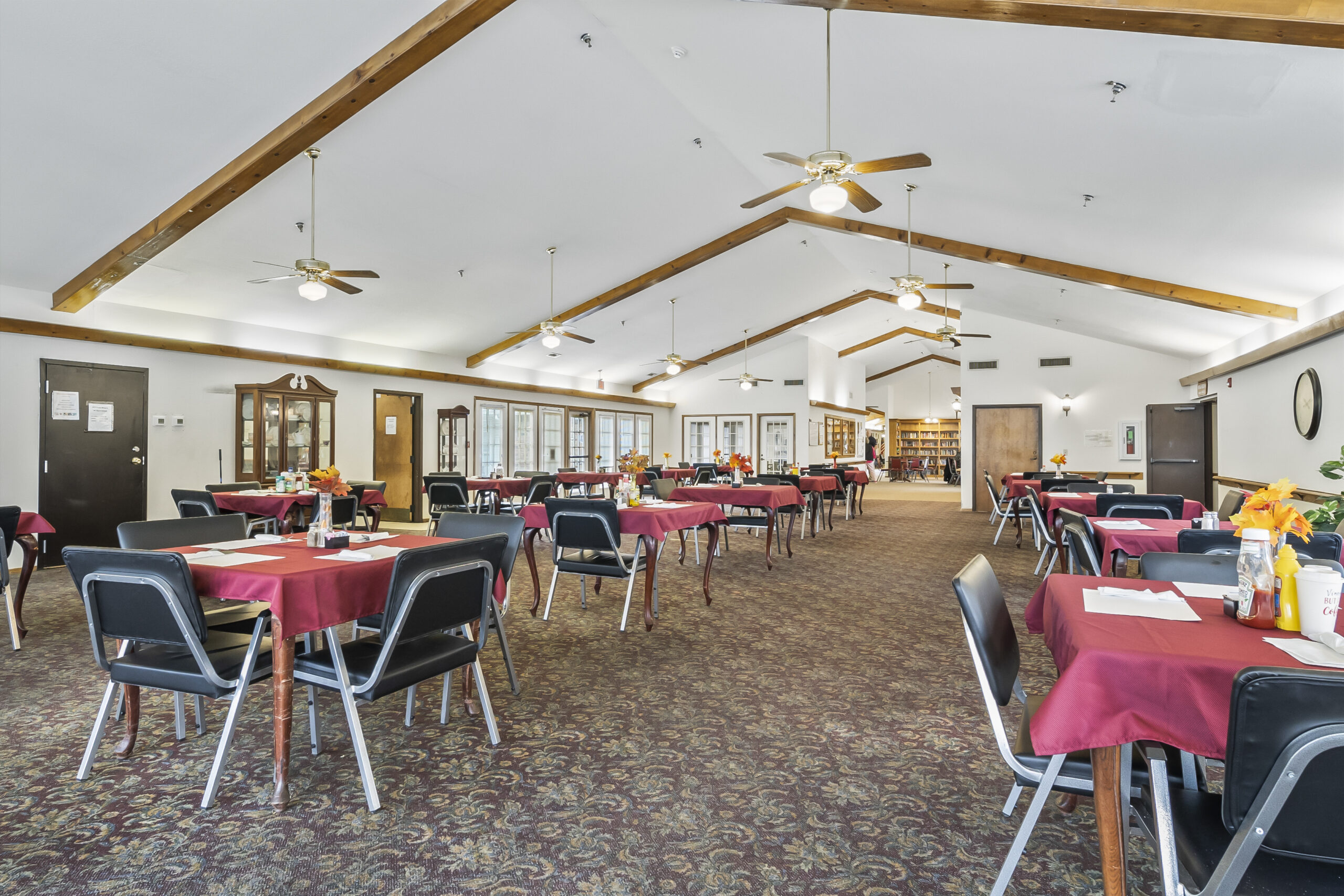 Bright dining room with red-covered tables