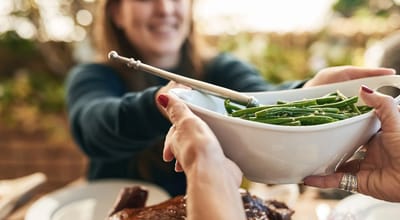 Friends sharing a meal together with green beans