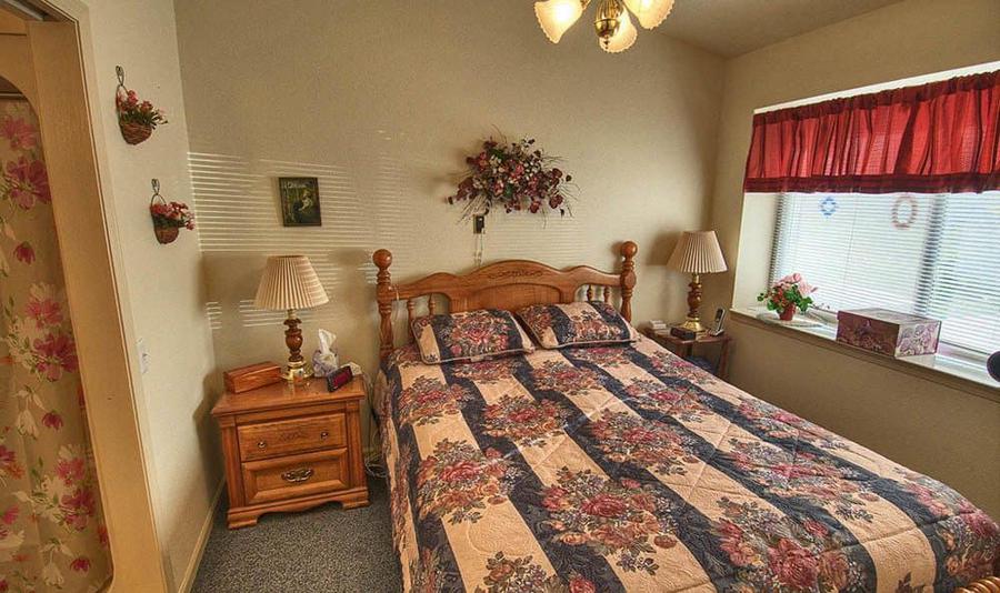 Cozy bedroom with floral decor and a patterned quilt