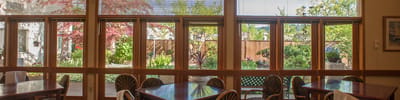 Interior view of a dining room with outdoor garden visible