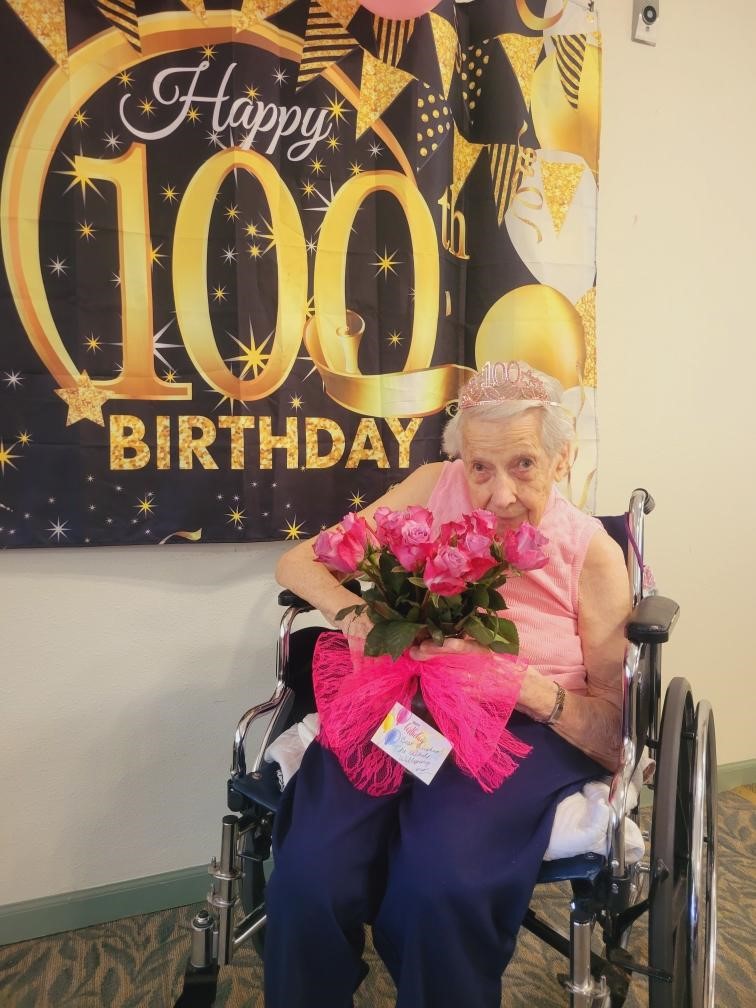 Resident celebrating 100th birthday with flowers