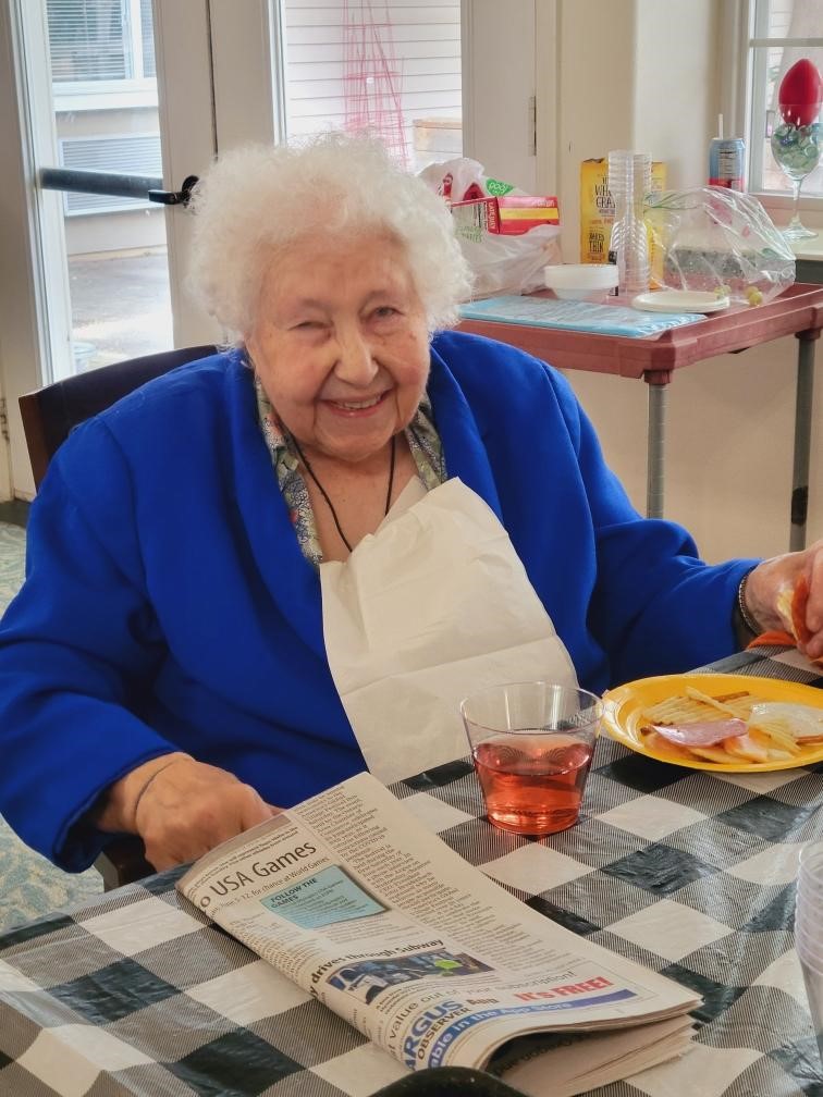 Resident smiling while eating at a dining table