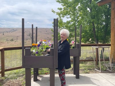 Resident tending to flowers in a garden area