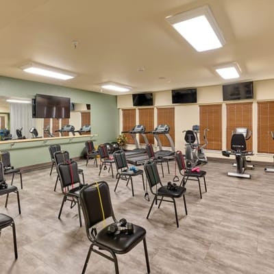 Interior view of a fitness room with equipment and chairs