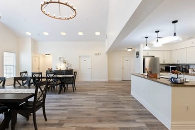 Spacious common area with dining tables and a kitchen