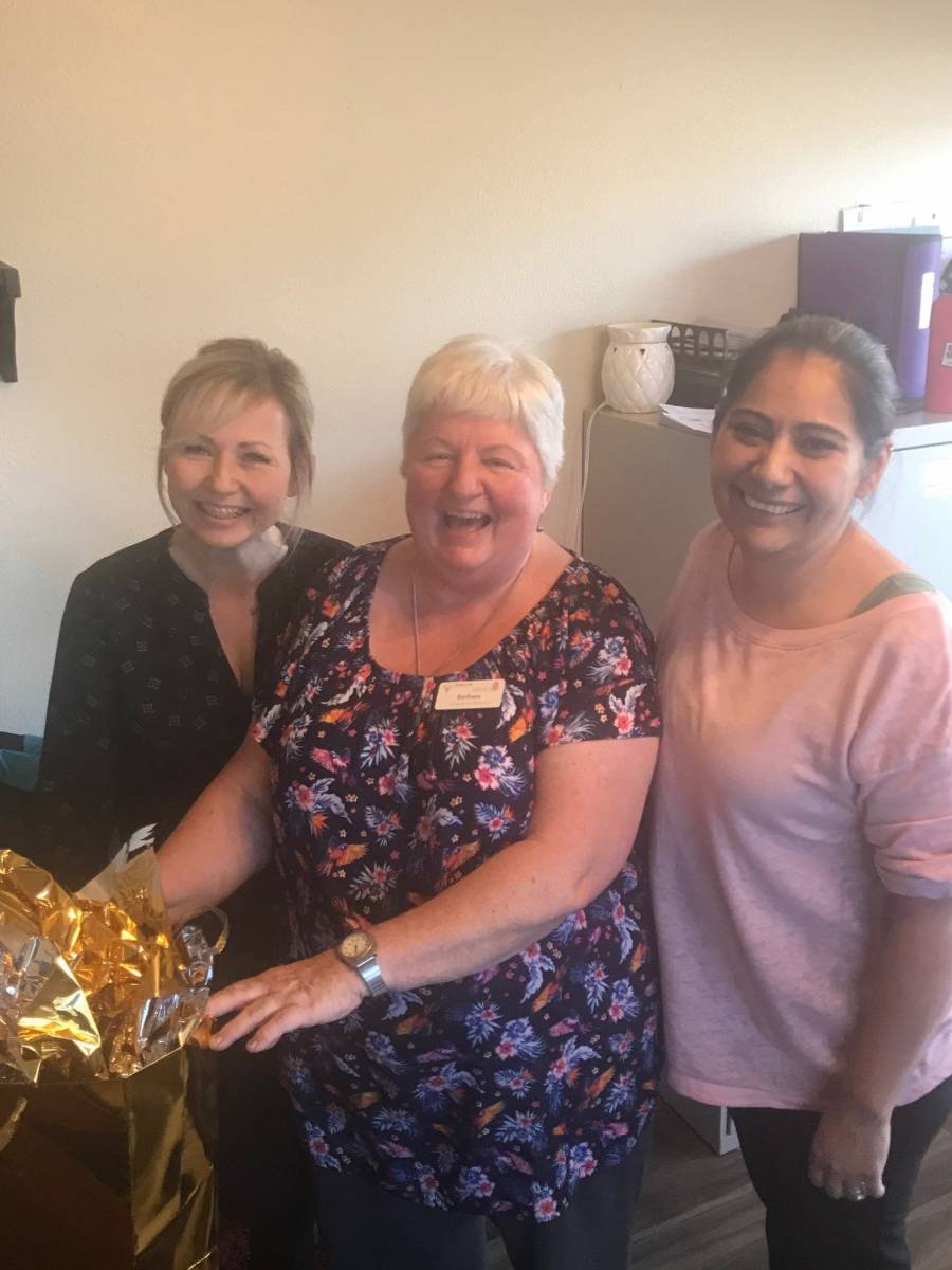 Staff celebrating with a resident in a common area