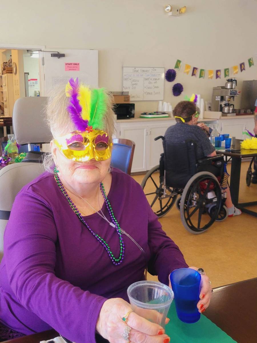 Resident participating in a festive activity with a mask.