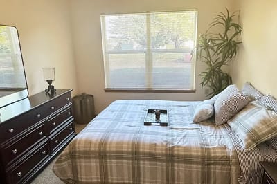 Well-furnished resident room with a bed and dresser