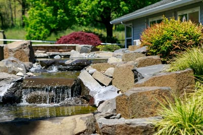 A serene outdoor space with a water feature and landscaping