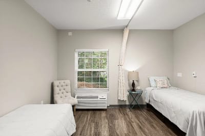 Private resident room with two beds and a window