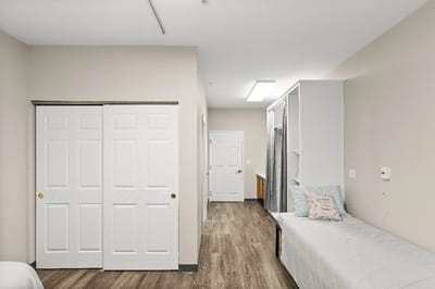 Interior view of a resident room with a bed and closet