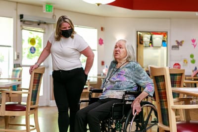 A staff member assisting a resident in a common area