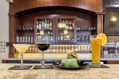 A selection of drinks and a wrap placed on a bar countertop