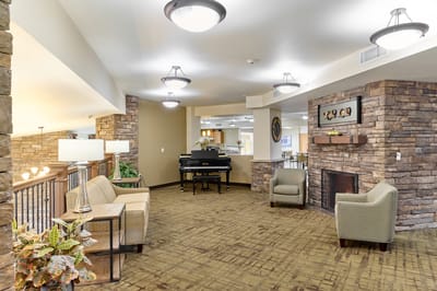 Common area with seating and piano in an assisted living facility