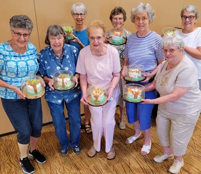 Residents celebrating with decorated cakes in an activity room