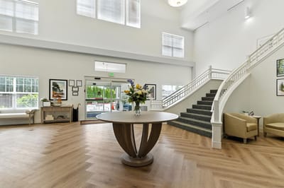 Interior shot of a spacious common area with stairs and plants