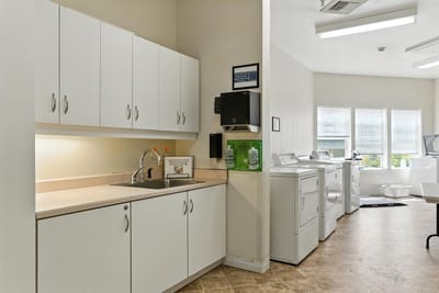 Interior laundry room with white cabinets and appliances