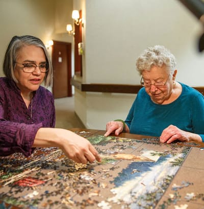 Residents and staff engage in a puzzle activity