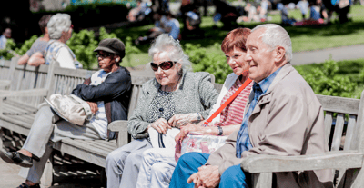 Seniors enjoying time on a bench in an outdoor park