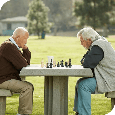 Two residents playing chess in an outdoor space
