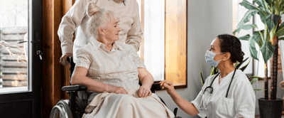 Healthcare worker interacting with a resident in a wheelchair