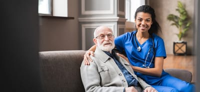 Resident and caregiver in a cozy facility lounge