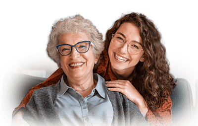 A smiling resident and staff member in a cozy living area