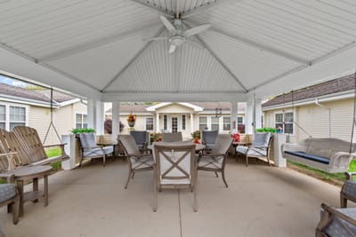 Covered outdoor seating area with chairs and tables