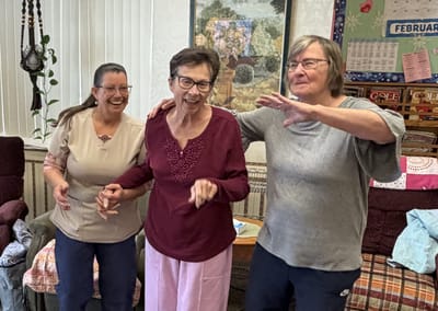Residents and staff joyfully dancing together