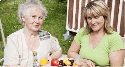 Two women enjoying a meal in an outdoor setting