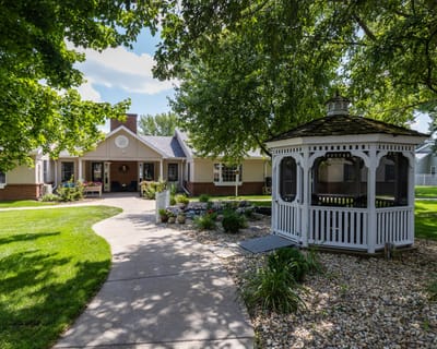 Exterior view of a senior living facility with a gazebo and pathway