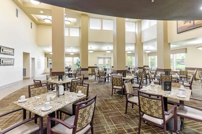 Dining room with tables and chairs set for residents